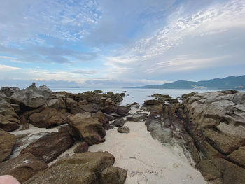 Rock formation on beach against sky