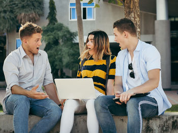 Young couple sitting on mobile phone