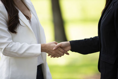 Midsection of couple holding hands