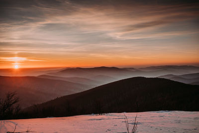 Scenic view of snowcapped mountains against sky during sunset