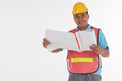 Smiling man holding umbrella against white background