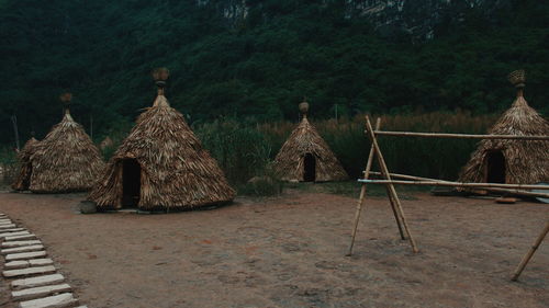 Built structure on land against trees on field against sky