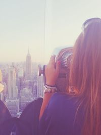 Rear view of woman with cityscape in background