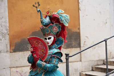 Person wearing mask against wall