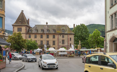 Cars on street in city against sky