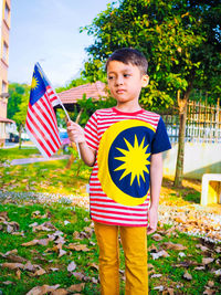 Low angle view of boy holding flag