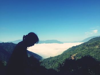 Man standing on mountain against clear sky