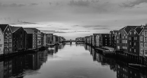 Canal amidst buildings in city against sky