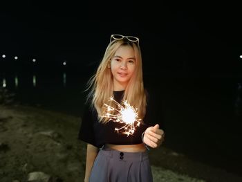 Portrait of young woman standing at river