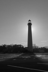 Lighthouse by building against clear sky