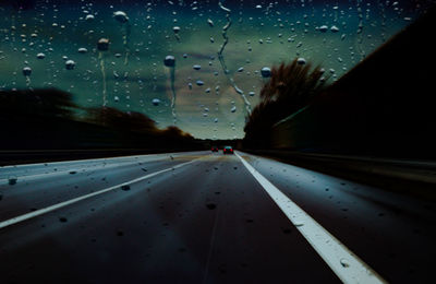 Wet road seen through car window