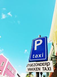 Low angle view of road sign against blue sky