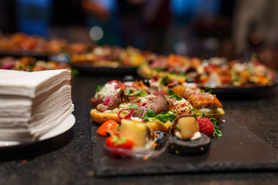 Set of beautiful canapes on black stone plates. buffet table. catering.