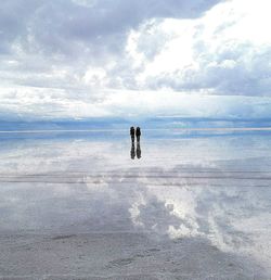 People standing on beach against sky