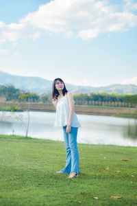 Full length of woman standing on field against sky