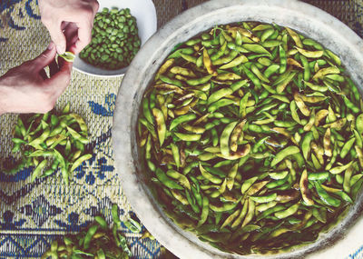 Cropped image of person shelling broad beans