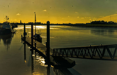 Pier over lake against sky during sunset