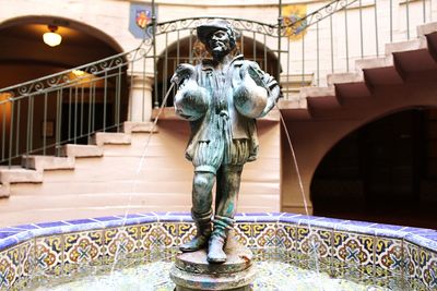 Statue of man standing against railing