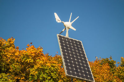 Low angle view of traditional windmill against clear blue sky