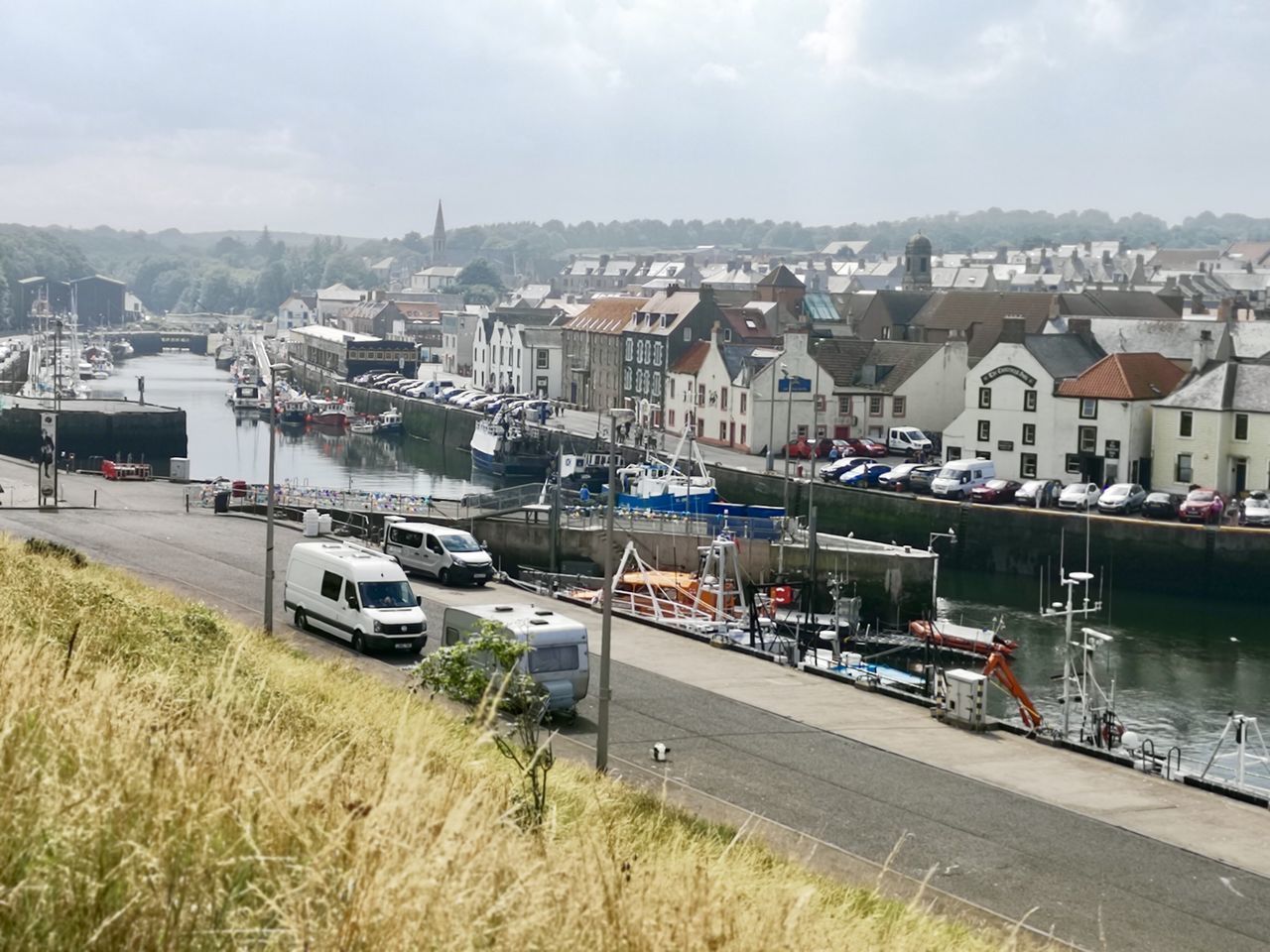 HIGH ANGLE VIEW OF HARBOR BY RIVER AGAINST SKY