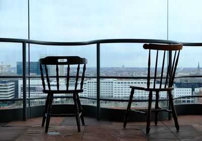 Close-up of chairs against sea against sky