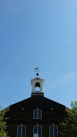 Low angle view of bell tower against blue sky