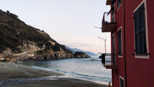 Scenic view of beach by buildings against sky