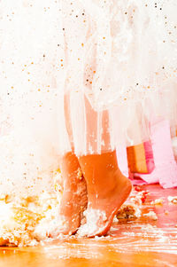 Low section of woman standing on messy floor