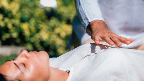 Reiki healing session. woman lying with her eyes closed, having reiki healing treatment.