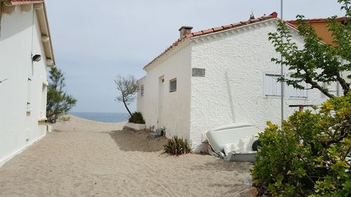 Houses by sea against sky