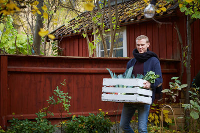 Man carrying freshly produce in basket at yard