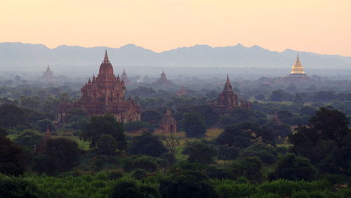 Ancient temples on field against clear sky