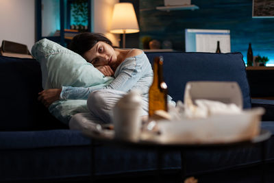 Depressed woman sitting on sofa at home