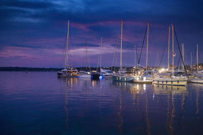 Sailboats in marina at harbor against sky