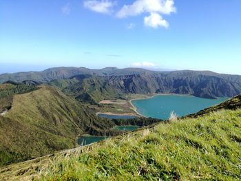 Scenic view of lake and mountains against blue sky