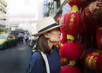 Mid adult woman looking at paper lanterns in city market