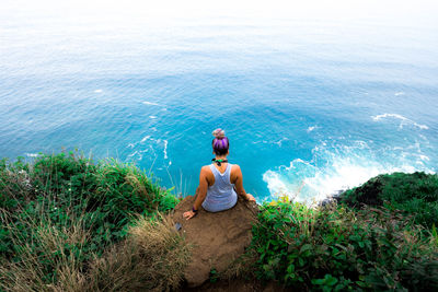 Man standing on cliff by sea