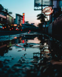 Reflection of building in puddle on street