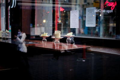 Reflection of illuminated glass on table at restaurant