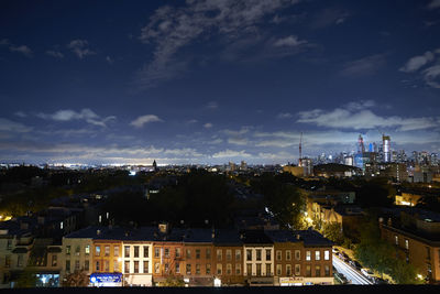 Buildings in city against cloudy sky