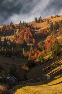 View of cottage on landscape against sky during autumn