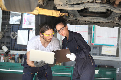 Young mechanics working at garage