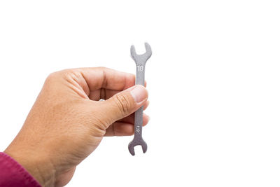 Close-up of hand holding cigarette against white background