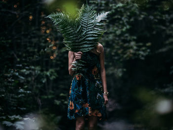 Midsection of person standing against tree