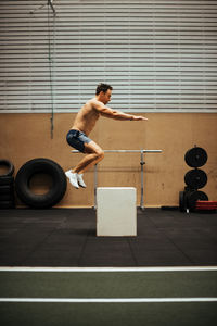 Shirtless man exercising in gym