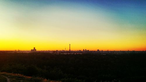 Silhouette buildings against sky during sunset