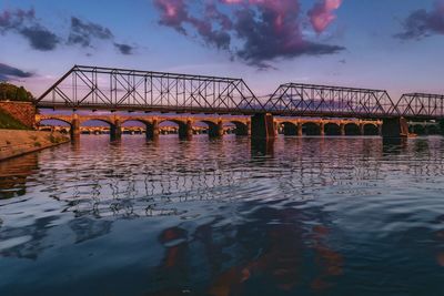 Bridge over river against cloudy sky