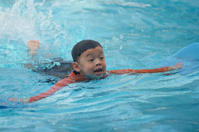 Portrait of boy swimming in pool