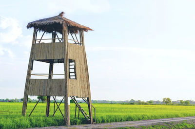 Traditional windmill on field against sky