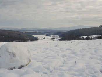 Scenic view of snow covered land against sky